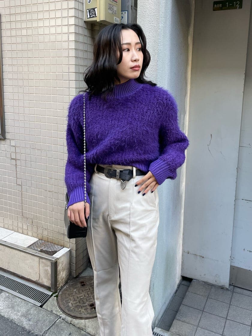 ブラック系のブーツ、パープル系のニット/セーター、ブラック系のショルダーバッグを着用したレディースの冬コーディネートの3枚目の写真