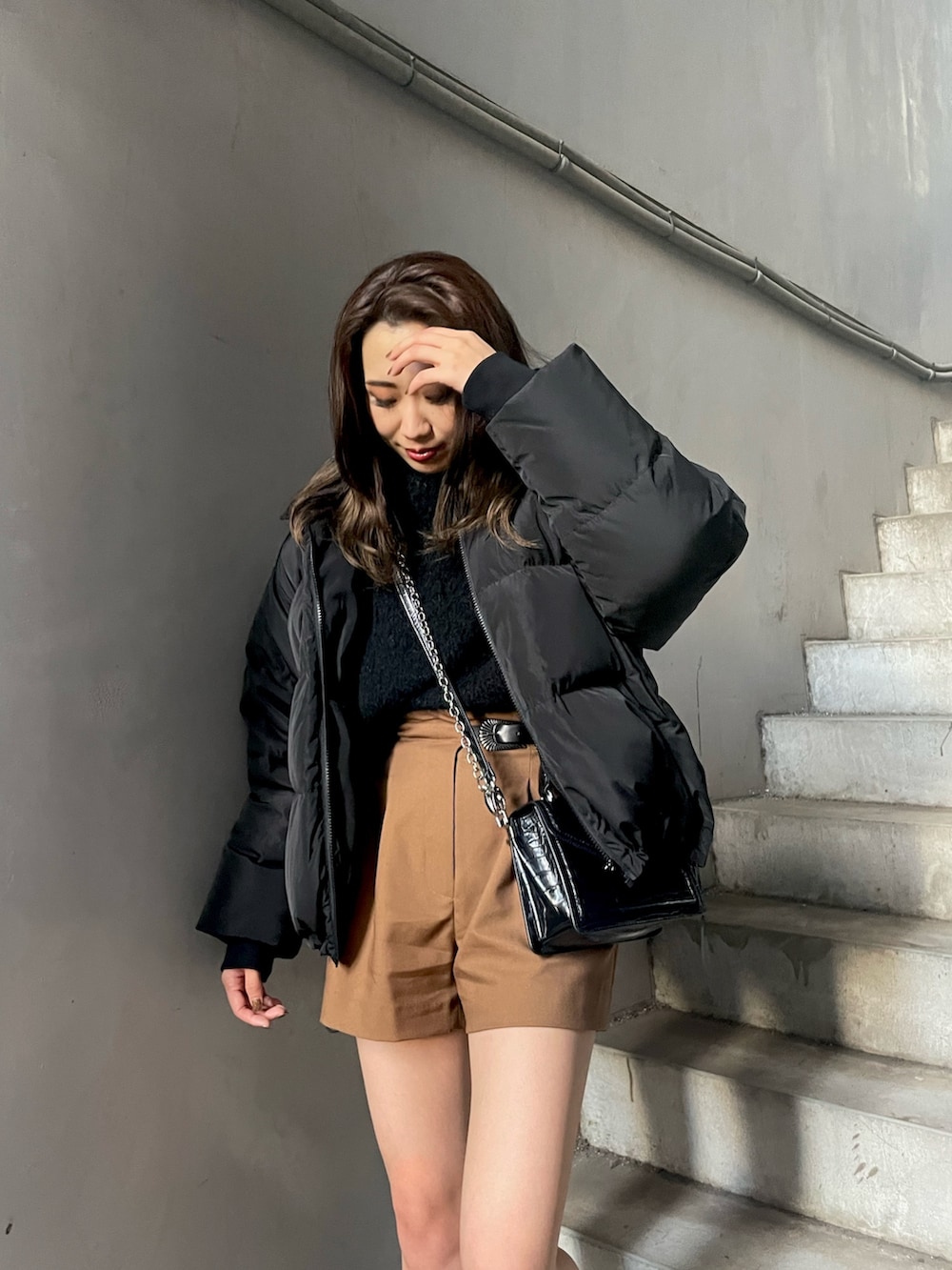 ブラウン系のその他パンツ、ブラック系のハンドバッグ、ブラック系のダウンジャケット/コートを着用したレディースの秋コーディネートの3枚目の写真