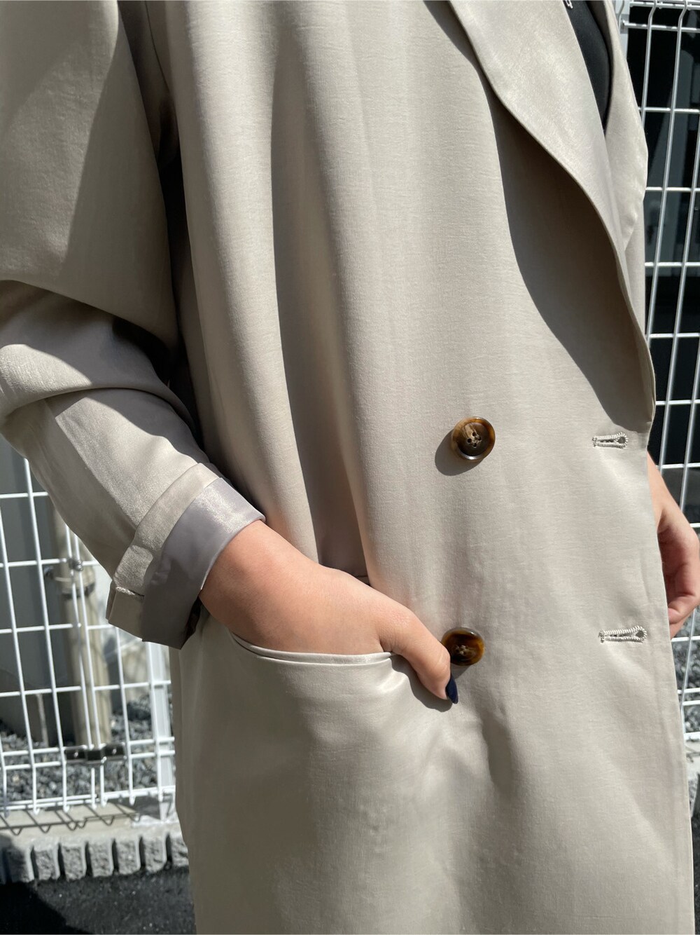 グレー系のテーラードジャケット、ブラック系のタンクトップ、ブラック系のサンダルを着用したレディースの春コーディネートの7枚目の写真