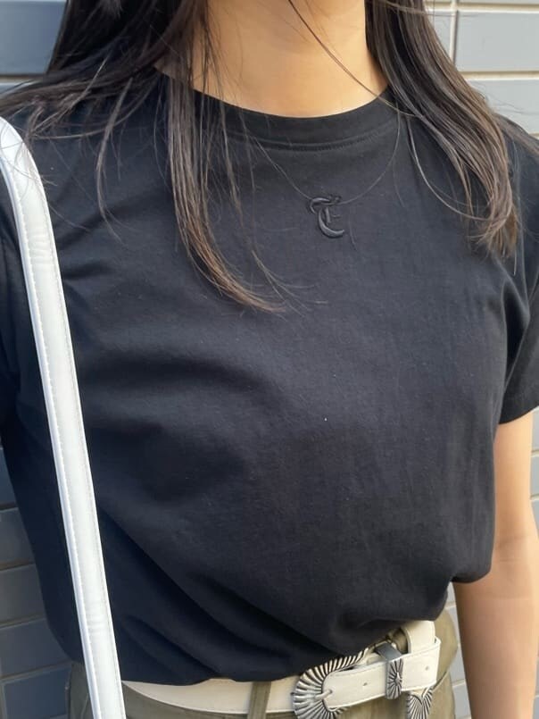 ブラック系のTシャツ/カットソー、ベージュ系のデニムパンツ、ホワイト系のベルトを着用したレディースの夏コーディネートの6枚目の写真