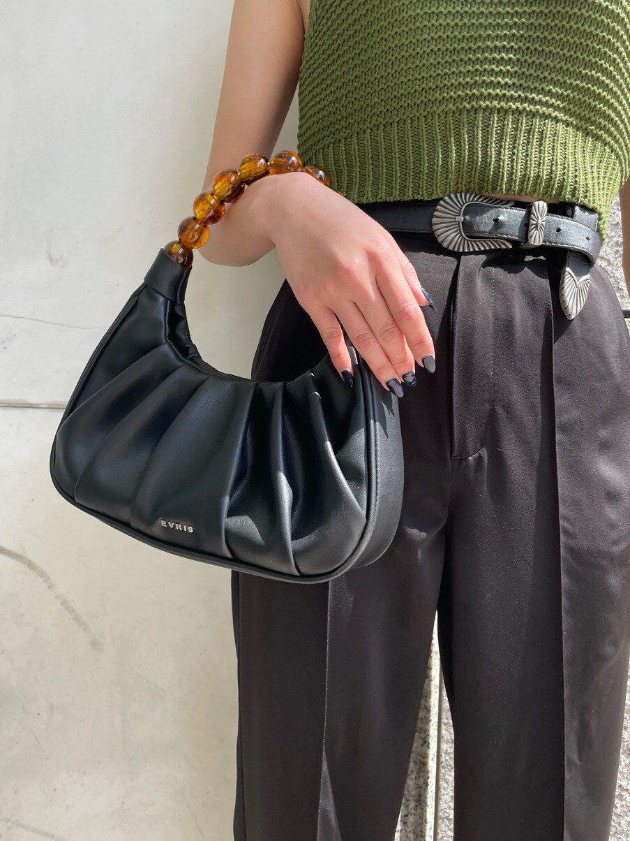 ブラック系のパンプス、ブラック系のその他パンツ、ブラック系のハンドバッグを着用したレディースの春コーディネートの5枚目の写真