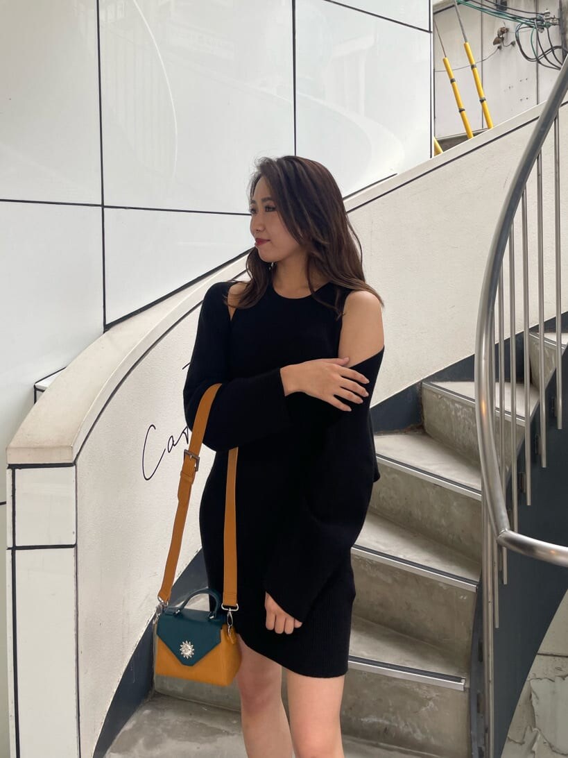 ブラック系のワンピース、ブラック系のブーツ、イエロー系のショルダーバッグを着用したレディースの秋コーディネートの3枚目の写真