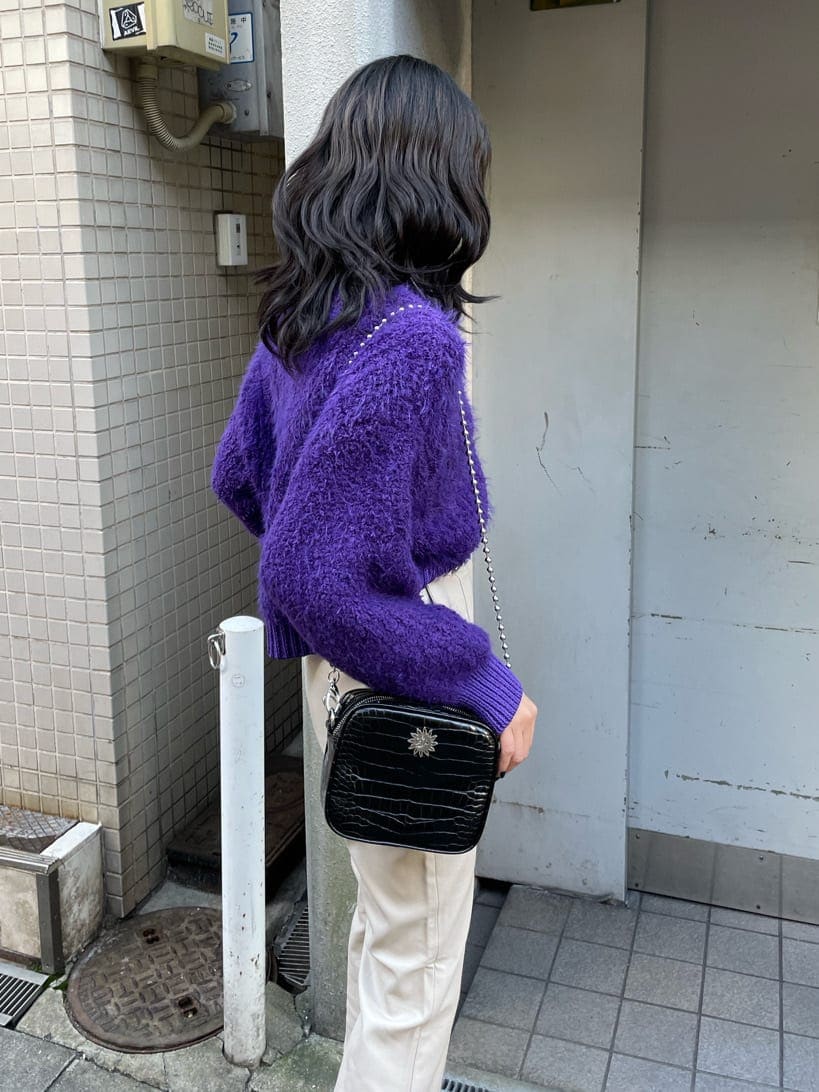 ブラック系のブーツ、パープル系のニット/セーター、ブラック系のショルダーバッグを着用したレディースの冬コーディネートの5枚目の写真