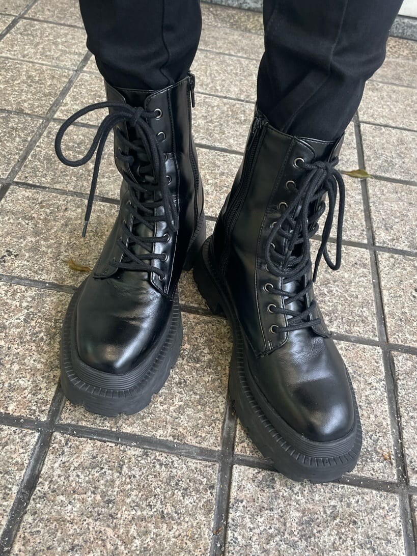 ブラック系のブーツ、ブラック系のデニムパンツ、ブラック系のショルダーバッグを着用したレディースの秋コーディネートの10枚目の写真