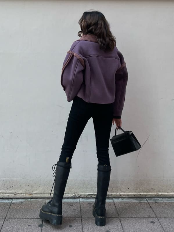 ブラック系のブーツ、パープル系のブルゾン、ブラック系のショルダーバッグを着用したレディースの冬コーディネートの2枚目の写真