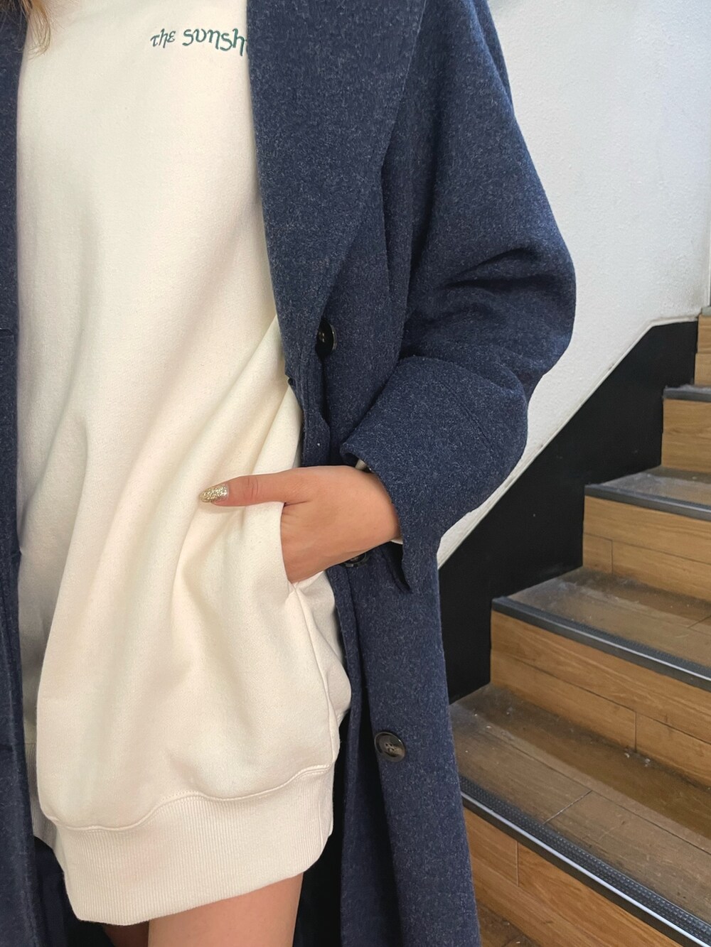 ブラック系のブーツ、ホワイト系のスウェット、ブルー系のその他アウターを着用したレディースの冬コーディネートの9枚目の写真