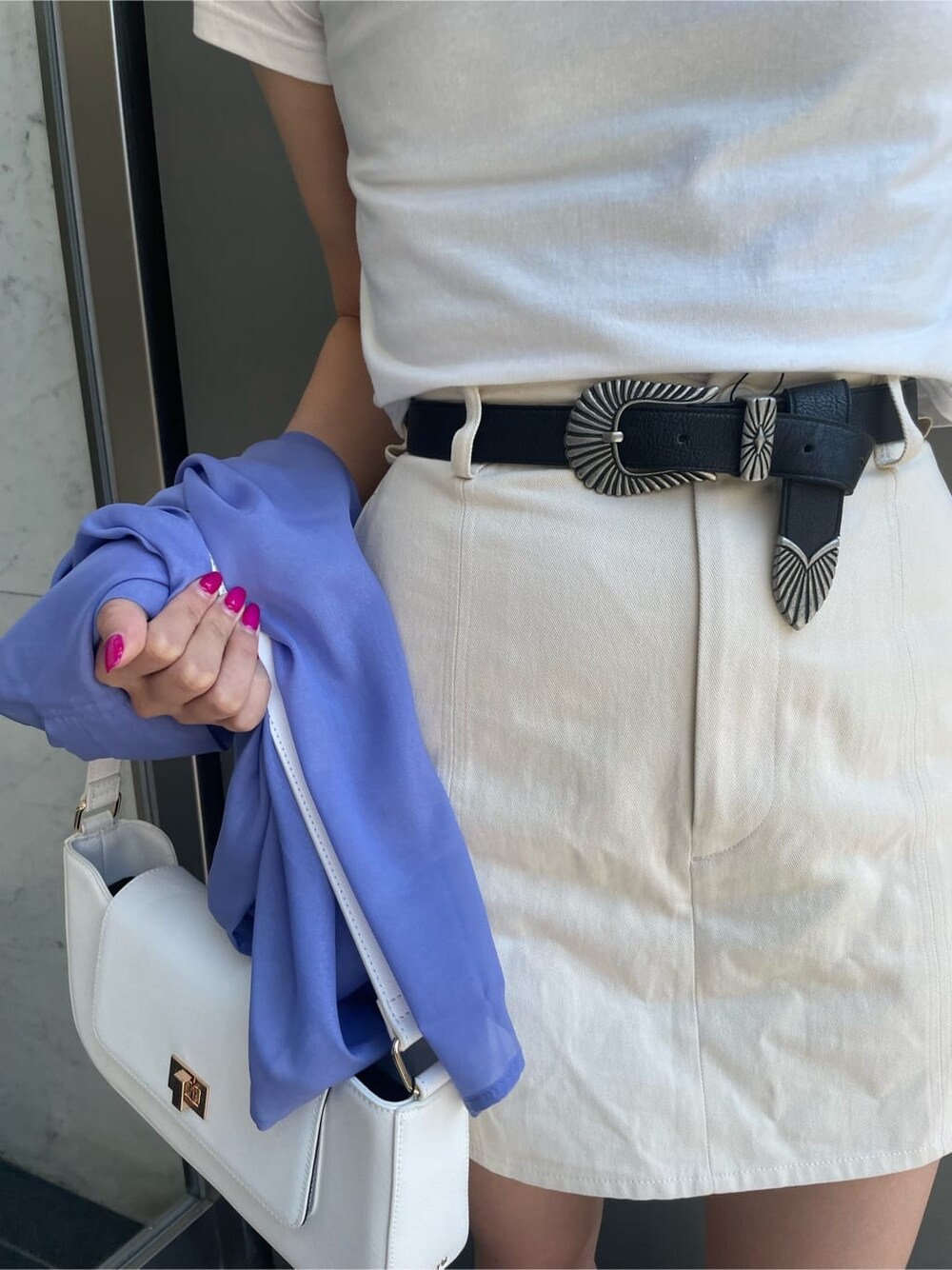 ホワイト系のTシャツ/カットソー、ホワイト系のスカート、ホワイト系のサンダルを着用したレディースの春コーディネートの6枚目の写真