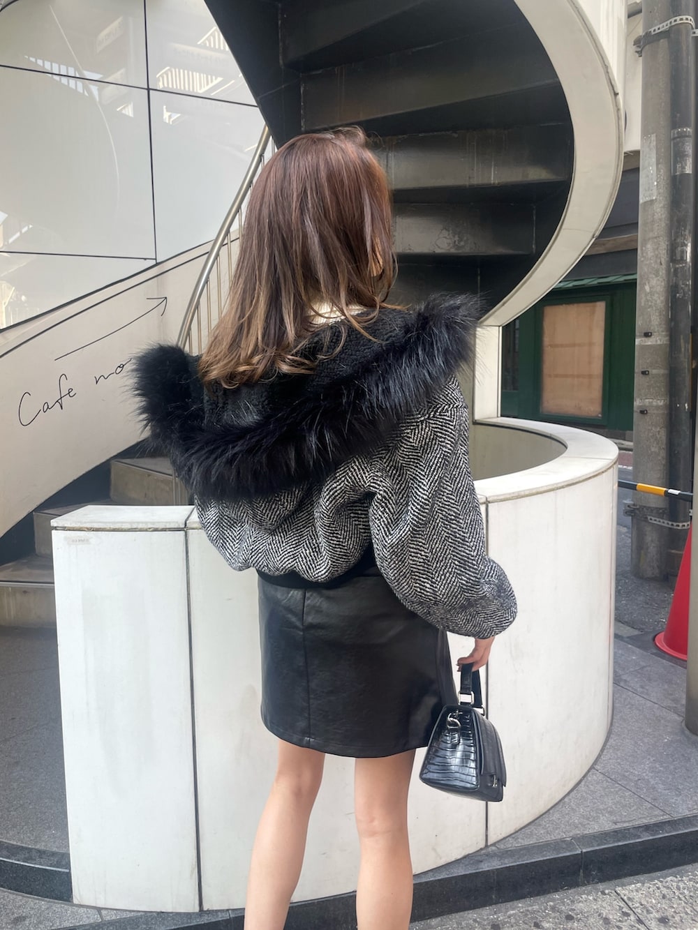 ブラック系のショルダーバッグ、ブラック系のブーツ、ブラック系のスカートを着用したレディースの秋コーディネートの5枚目の写真