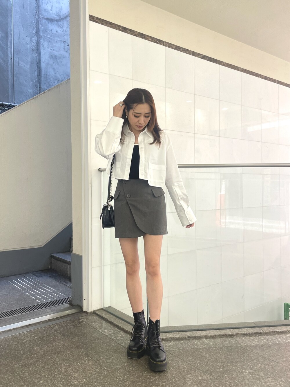 グレー系のスカート、ブラック系のブーツ、ブラック系のキャミソールを着用したレディースの春コーディネートの2枚目の写真