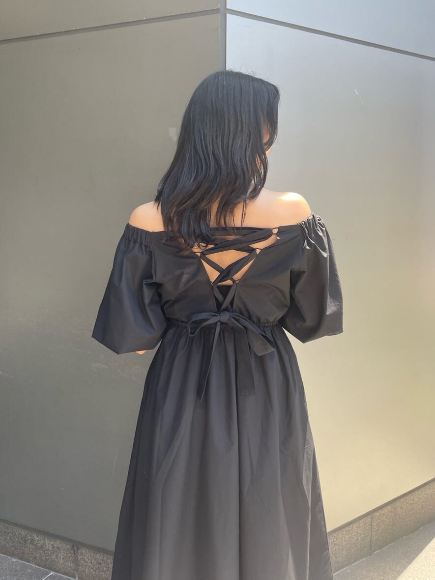 ブラック系のワンピース、ホワイト系のサンダル、ホワイト系のショルダーバッグを着用したレディースの春コーディネートの3枚目の写真