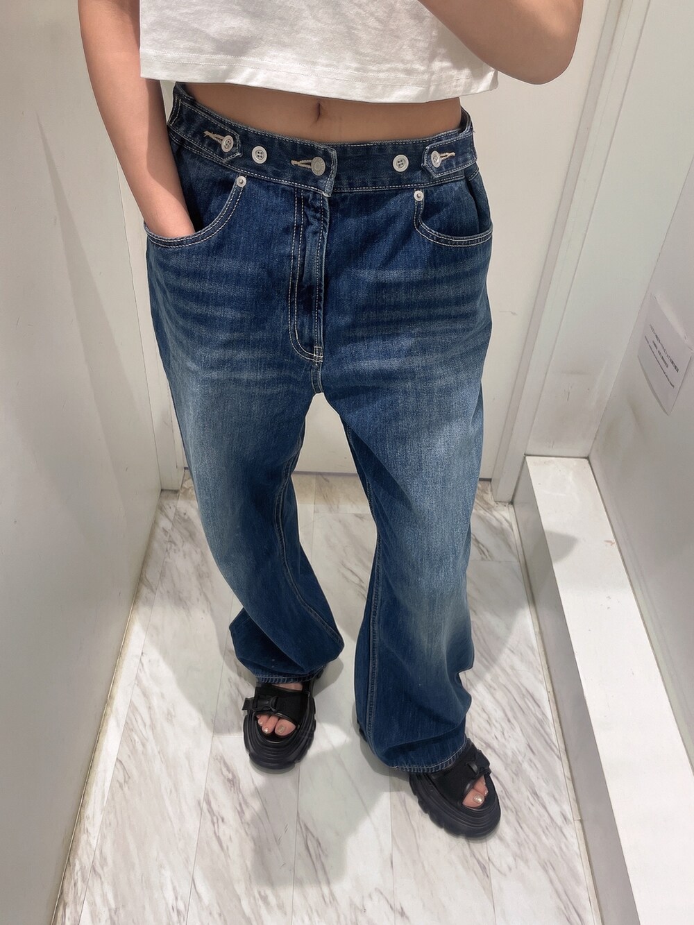 ホワイト系のTシャツ/カットソー、ブルー系のデニムパンツ、ブラック系のサンダルを着用したレディースの春コーディネートの4枚目の写真