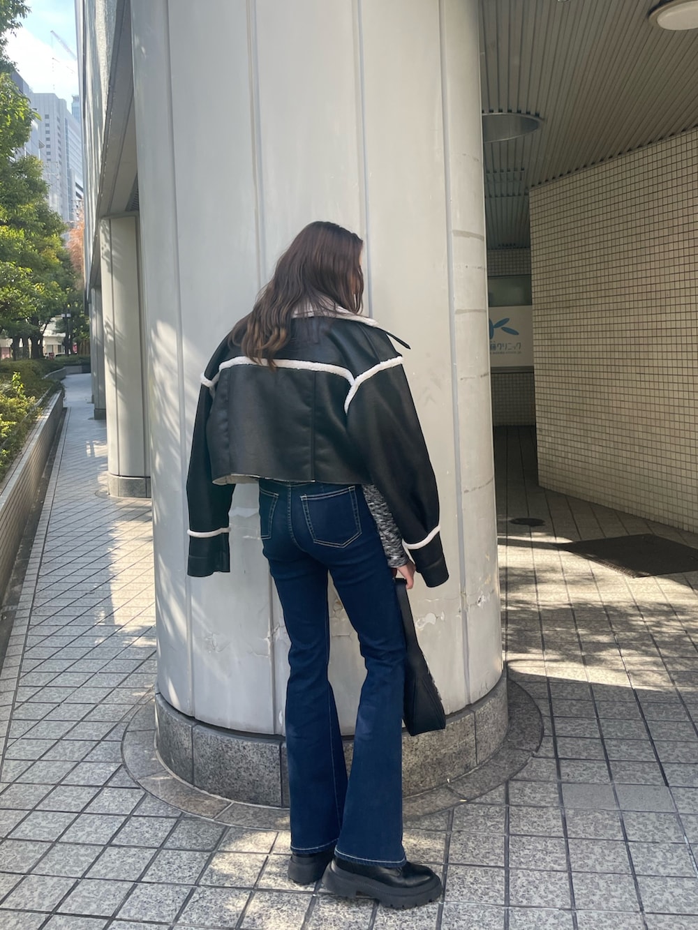 ブラック系のブルゾン、ブラック系のニット/セーター、ブルー系のデニムパンツを着用したレディースの冬コーディネートの3枚目の写真