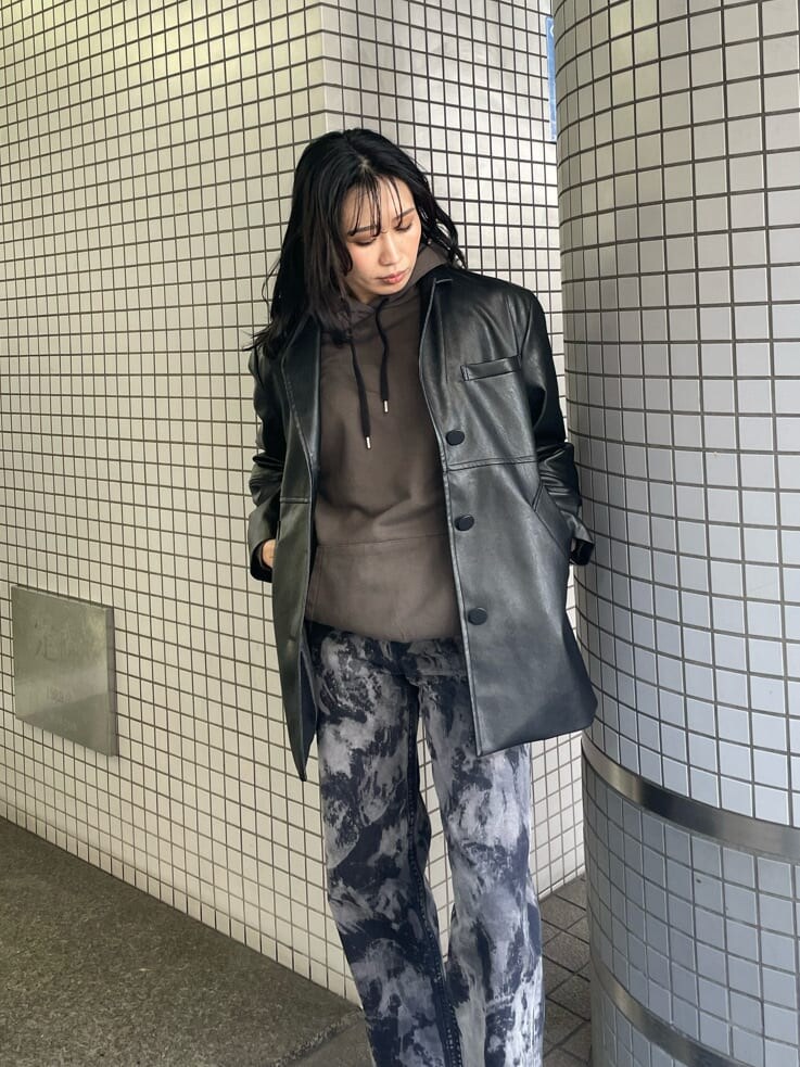 ブラック系のテーラードジャケット、ベージュ系のブーツ、ブラック系のデニムパンツを着用したレディースの春コーディネートの4枚目の写真