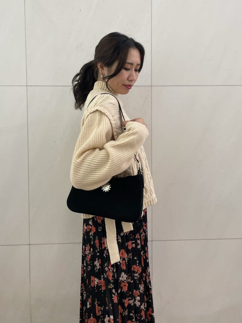 ブラック系のショルダーバッグ、ホワイト系のニット/セーター、ブラック系のスカートを着用したレディースの秋コーディネートの4枚目の写真