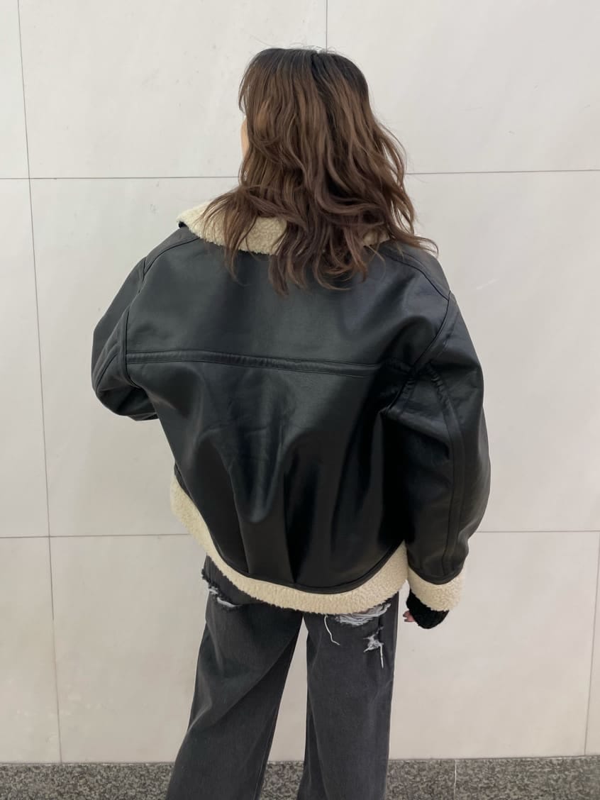 ブラック系のデニムパンツ、ブラック系のブルゾン、ブラック系のニット/セーターを着用したレディースの秋コーディネートの4枚目の写真