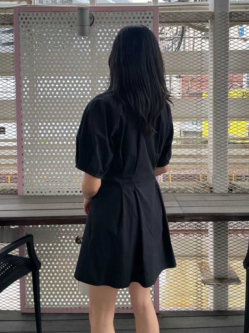 ブラック系のブーツ、ブラック系のワンピース、ホワイト系のショルダーバッグを着用したレディースの春コーディネートの5枚目の写真