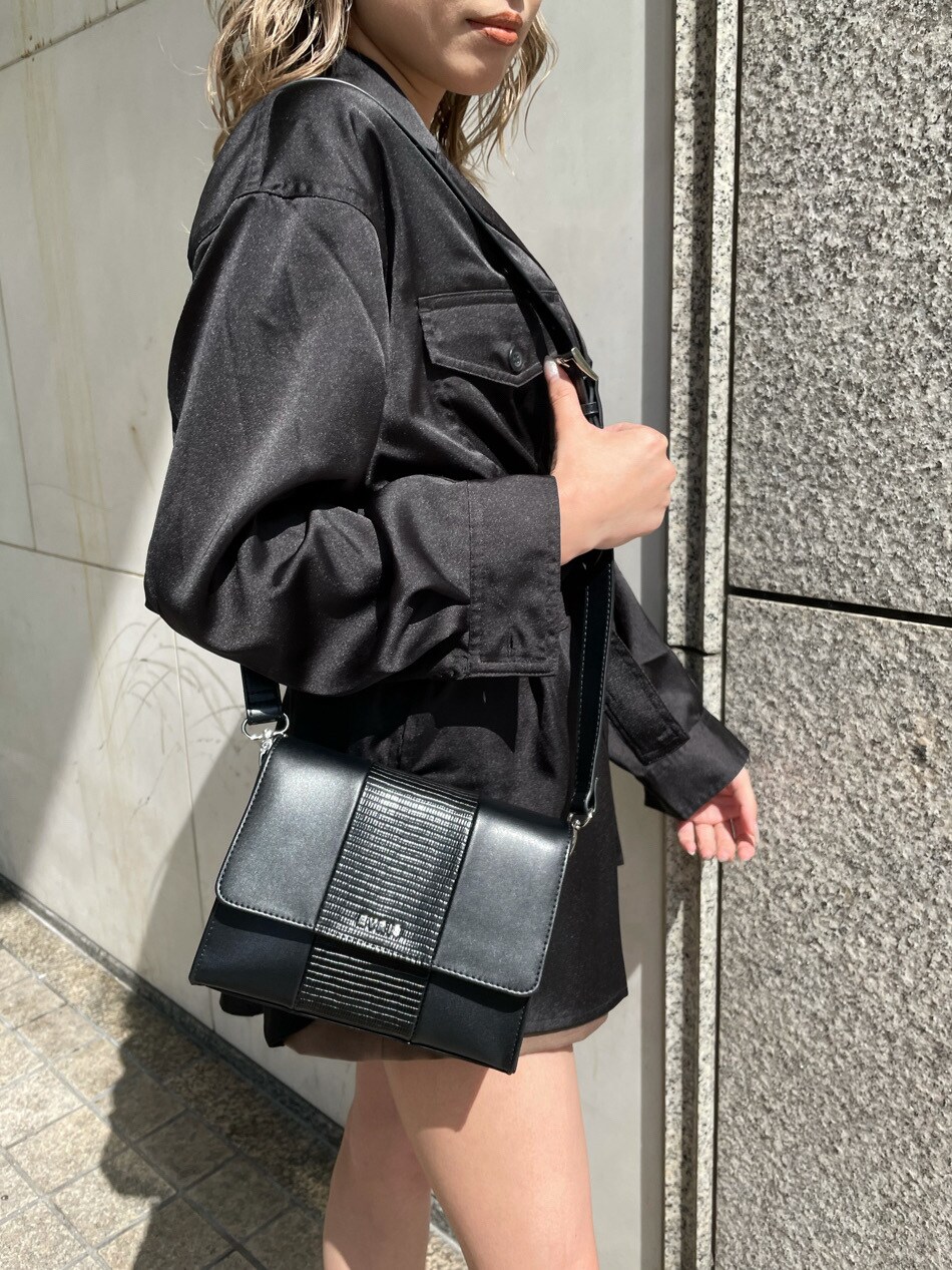 ブラウン系のスカート、ブラック系のショルダーバッグ、ブラック系のテーラードジャケットを着用したレディースの春コーディネートの5枚目の写真