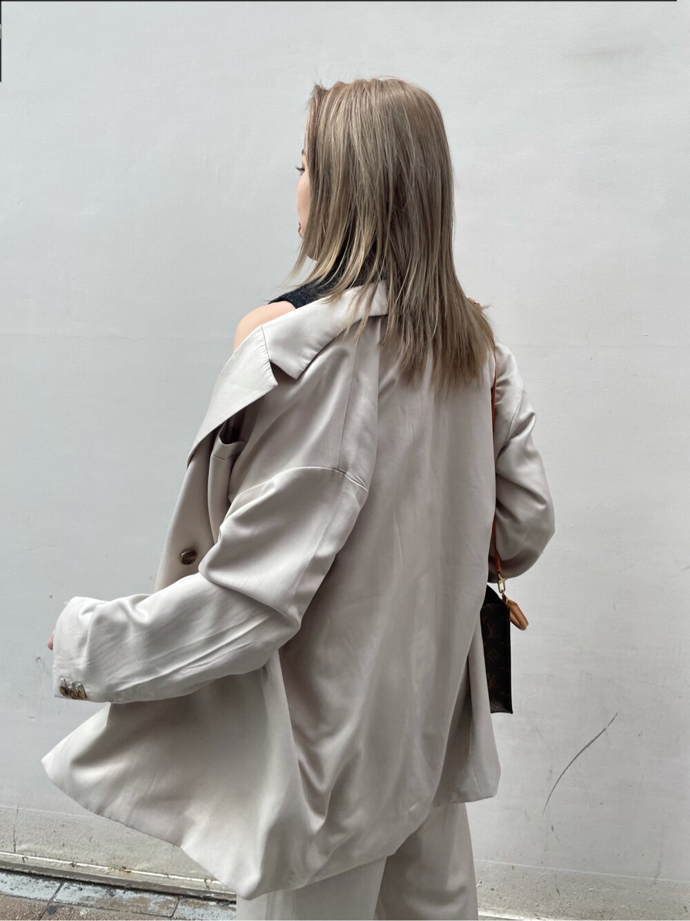 グレー系のテーラードジャケット、ブラック系のパンプス、ブラック系のタンクトップを着用したレディースの春コーディネートの5枚目の写真