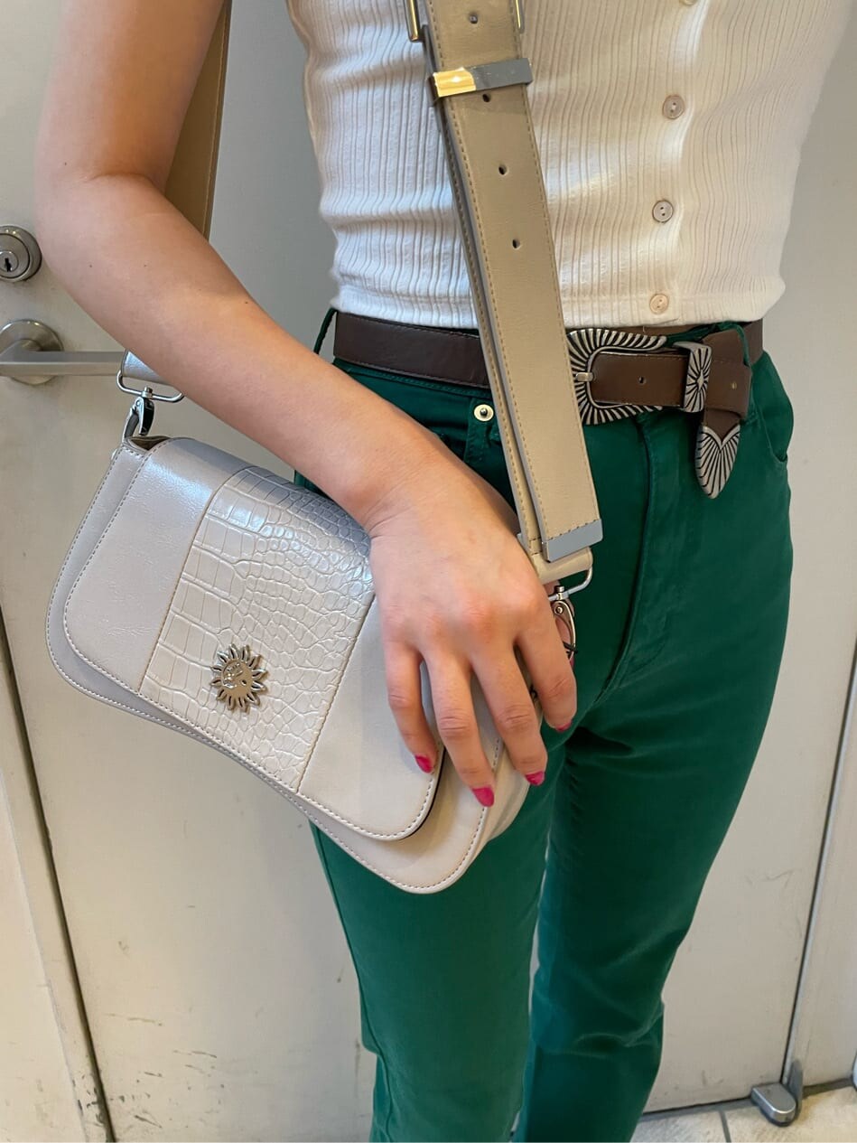 ブラック系のブーツ、ホワイト系のTシャツ/カットソー、グリーン系のデニムパンツを着用したレディースの春コーディネートの6枚目の写真