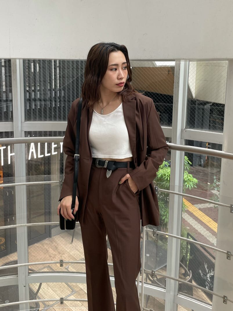 ブラック系のローファー、ブラック系のハンドバッグ、ホワイト系のTシャツ/カットソーを着用したレディースの夏コーディネートの3枚目の写真