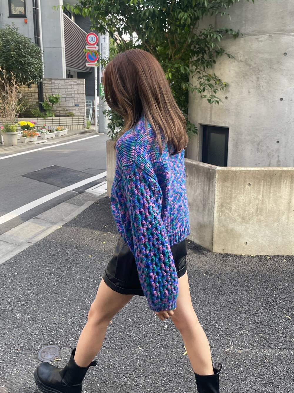 ブルー系のニット/セーター、ブラック系のブーツ、ブラック系のショルダーバッグを着用したレディースの秋コーディネートの5枚目の写真