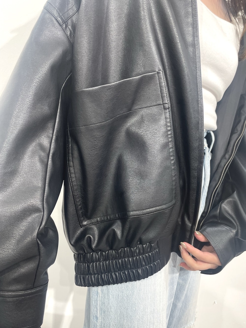 ブルー系のデニムパンツ、ブラック系のショルダーバッグ、ホワイト系のTシャツ/カットソーを着用したレディースの秋コーディネートの5枚目の写真