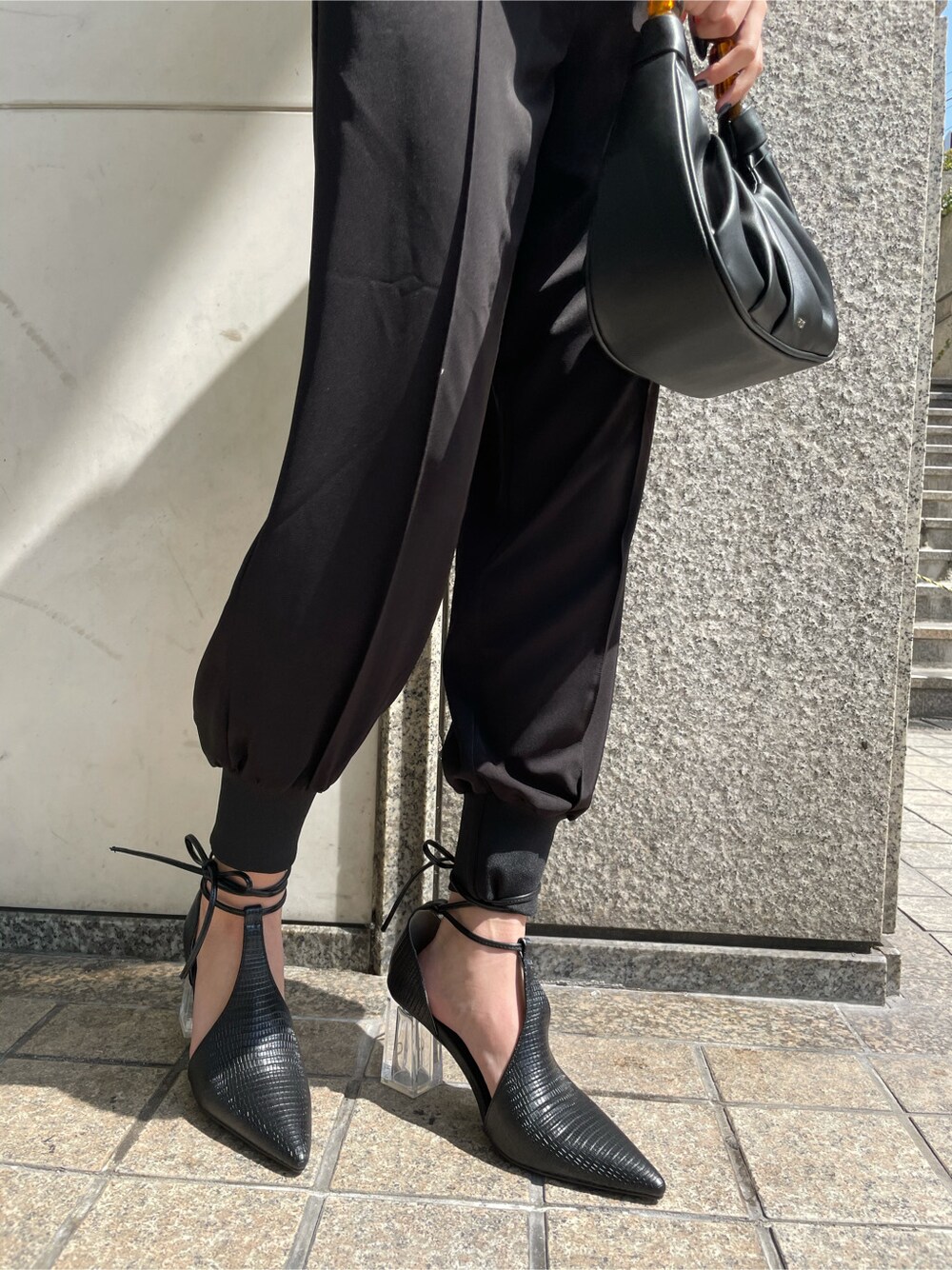 ブラック系のパンプス、ブラック系のその他パンツ、ブラック系のハンドバッグを着用したレディースの春コーディネートの3枚目の写真