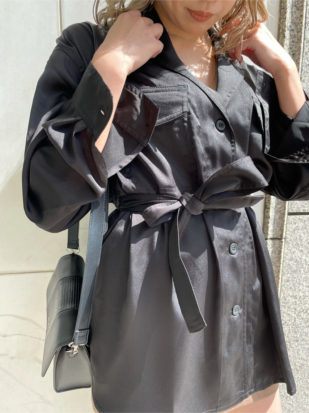 ブラウン系のスカート、ブラック系のショルダーバッグ、ブラック系のテーラードジャケットを着用したレディースの春コーディネートの2枚目の写真