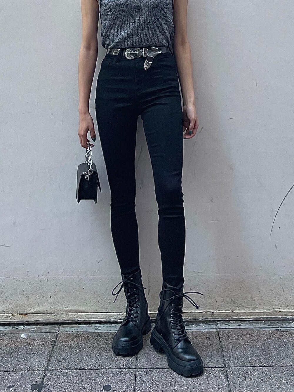 ブラック系のニット/セーター、ブラック系のブーツ、ブラック系のデニムパンツを着用したレディースの夏コーディネートの4枚目の写真