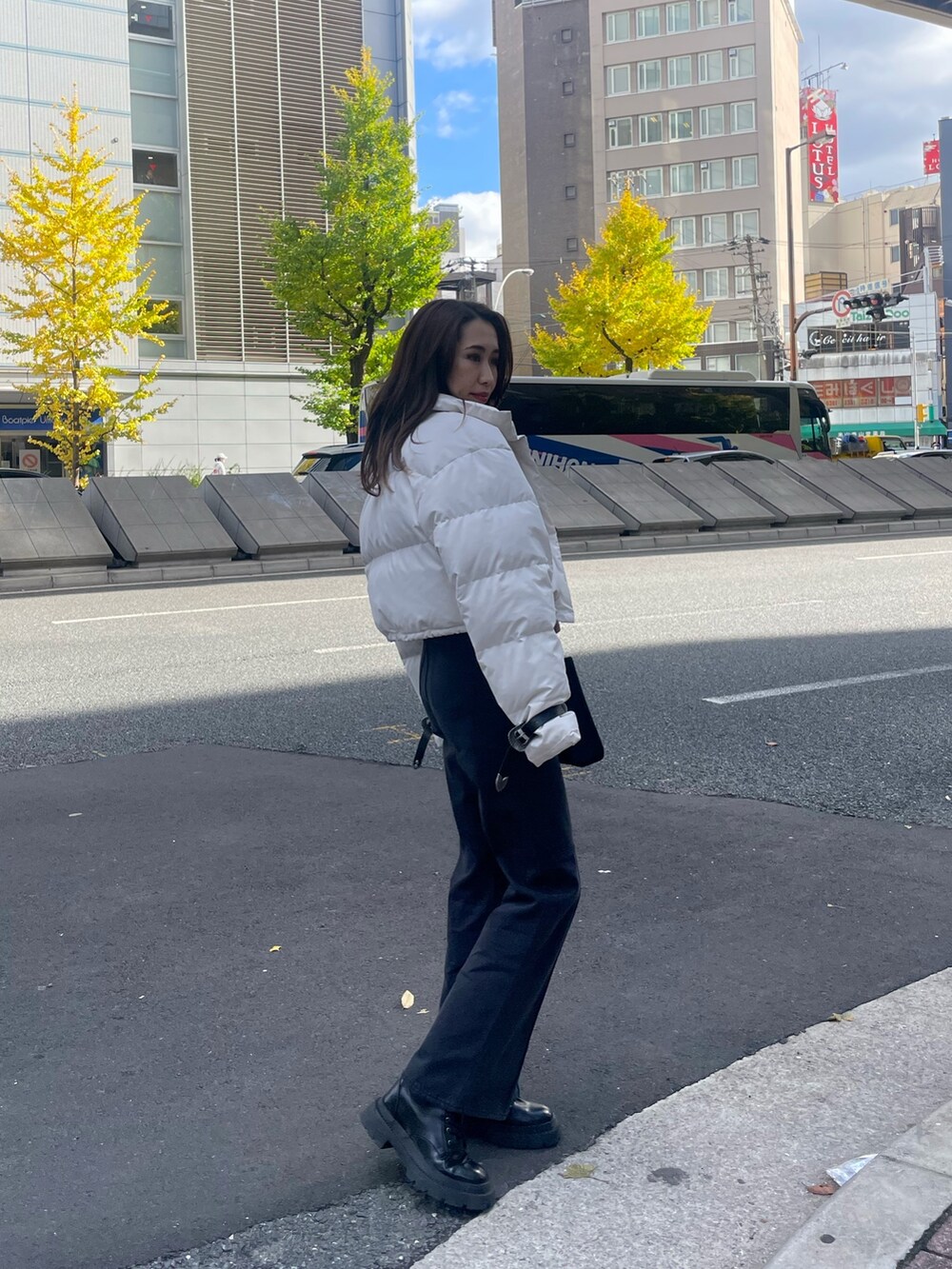 ホワイト系のダウンジャケット/コート、ブラック系のTシャツ/カットソー、ブラック系のショルダーバッグを着用したレディースの秋コーディネートの3枚目の写真