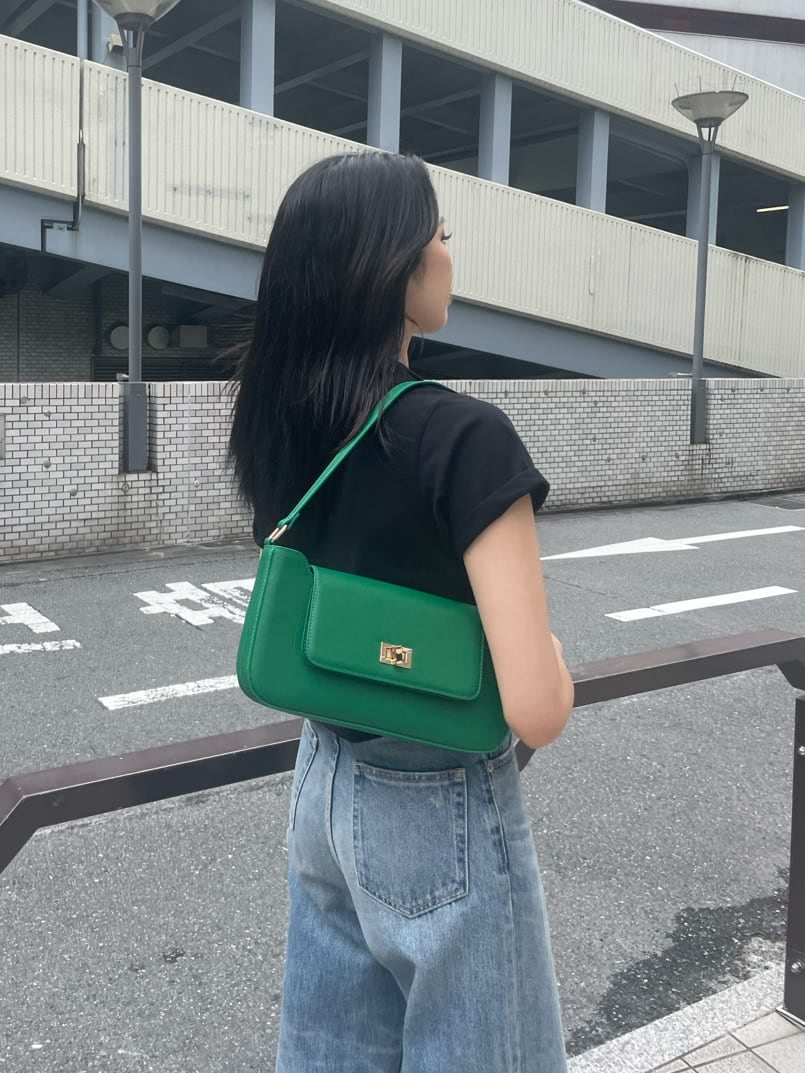 グリーン系のショルダーバッグ、ブルー系のデニムパンツ、ブラック系のスニーカーを着用したレディースの夏コーディネートの4枚目の写真