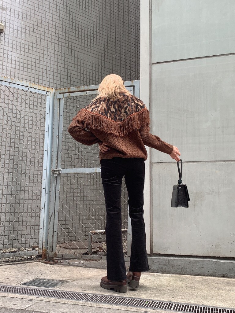 ブラウン系のブーツ、ブラウン系のニット/セーター、ブラック系のその他パンツを着用したレディースの秋コーディネートの2枚目の写真