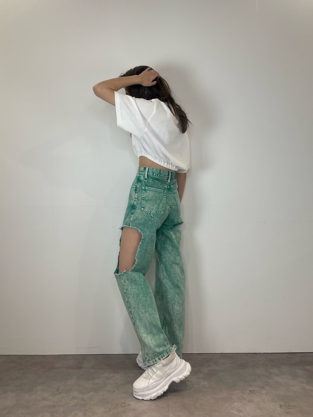 グリーン系のデニムパンツ、ホワイト系のスニーカー、ホワイト系のTシャツ/カットソーを着用したレディースの春コーディネートの3枚目の写真