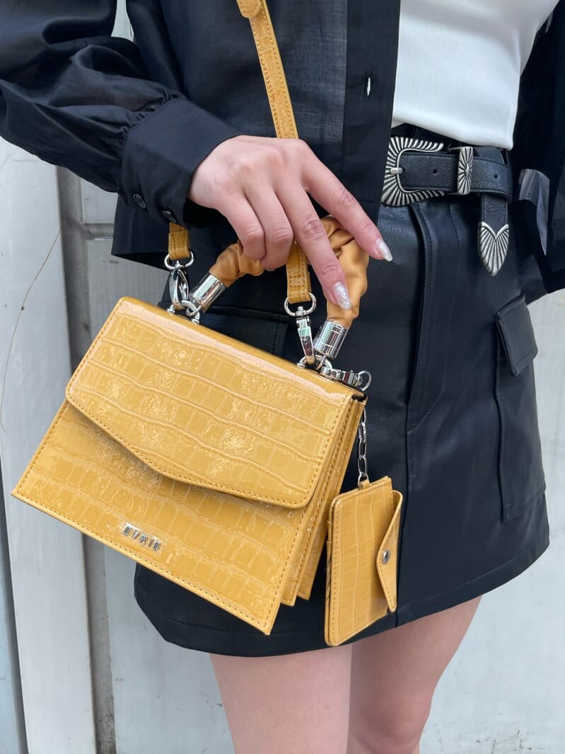 ホワイト系のキャミソール、ブラック系のブーツ、ブラック系のスカートを着用したレディースの春コーディネートの5枚目の写真