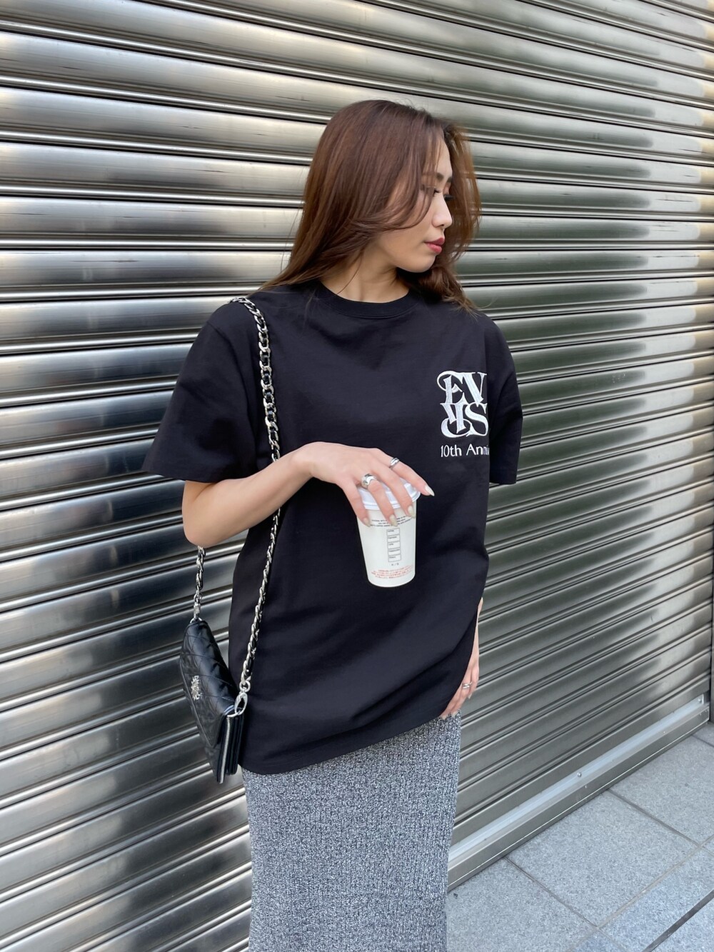 ブラック系のTシャツ/カットソー、ブラック系のショルダーバッグ、ブラック系のブーツを着用したレディースの春コーディネートの6枚目の写真