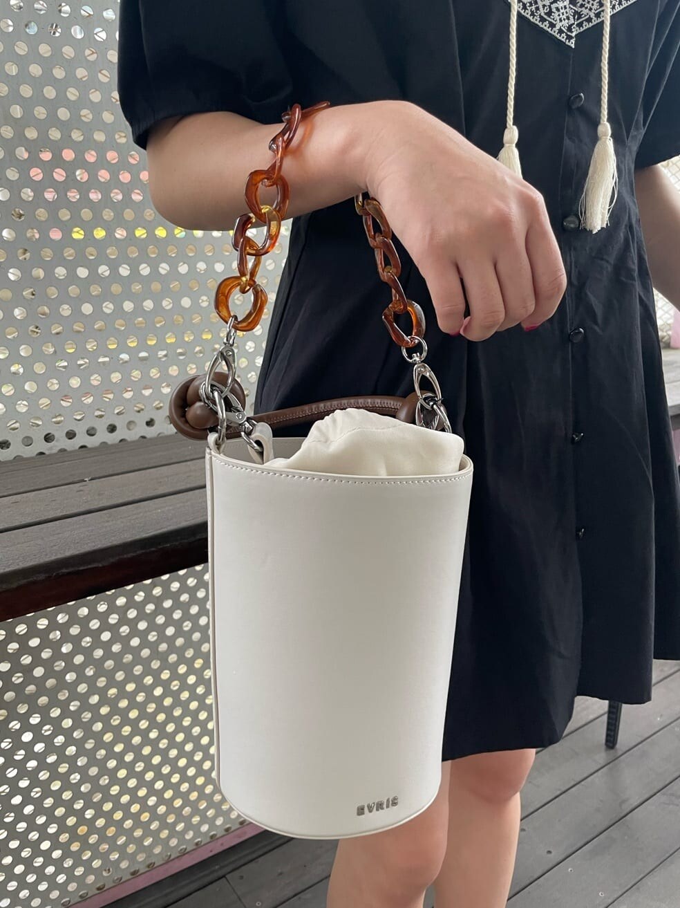 ブラック系のブーツ、ブラック系のワンピース、ホワイト系のショルダーバッグを着用したレディースの春コーディネートの7枚目の写真