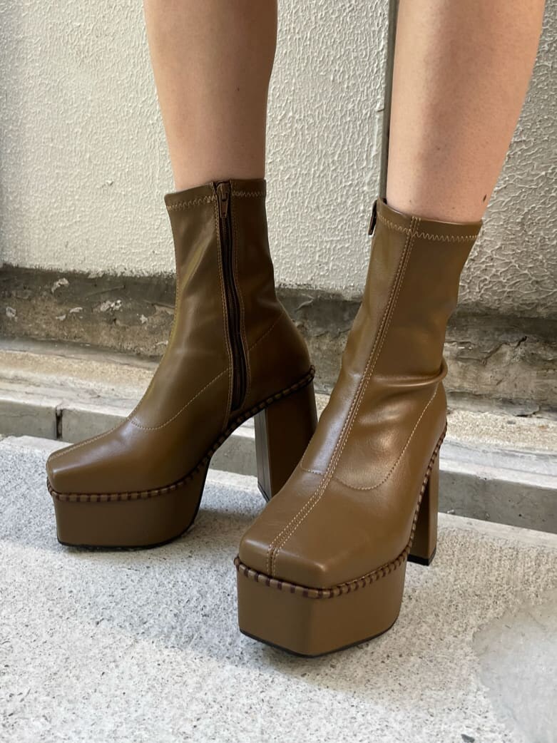 ベージュ系のブーツ、ホワイト系のニット/セーター、ブラック系のスカートを着用したレディースの秋コーディネートの6枚目の写真