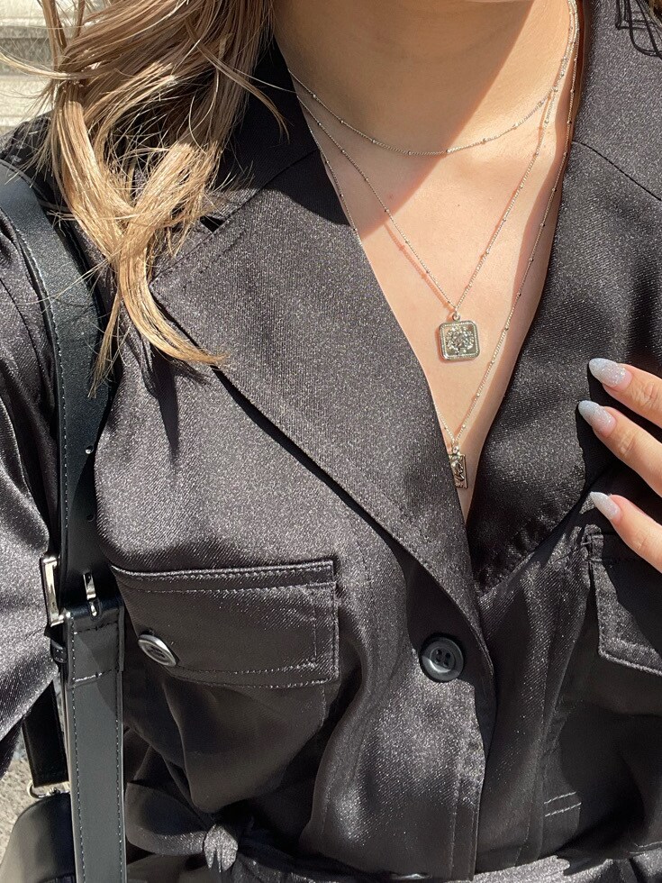 ブラウン系のスカート、ブラック系のショルダーバッグ、ブラック系のテーラードジャケットを着用したレディースの春コーディネートの7枚目の写真