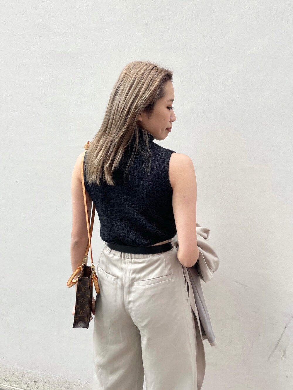 グレー系のテーラードジャケット、ブラック系のパンプス、ブラック系のタンクトップを着用したレディースの春コーディネートの4枚目の写真