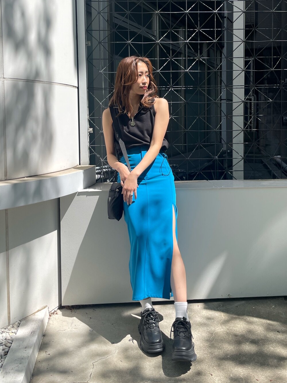 ブラック系のタンクトップ、ブラック系のスニーカーを着用したレディースの春コーディネートの2枚目の写真