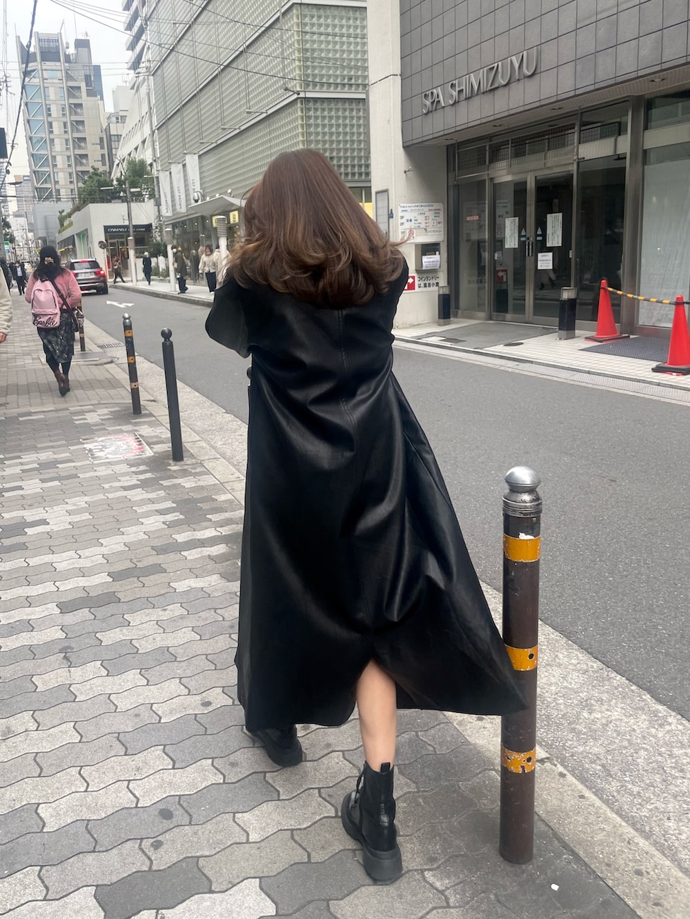 グレー系のニット/セーター、ブラック系のチェスターコート、ブラック系のデニムパンツを着用したレディースの冬コーディネートの2枚目の写真