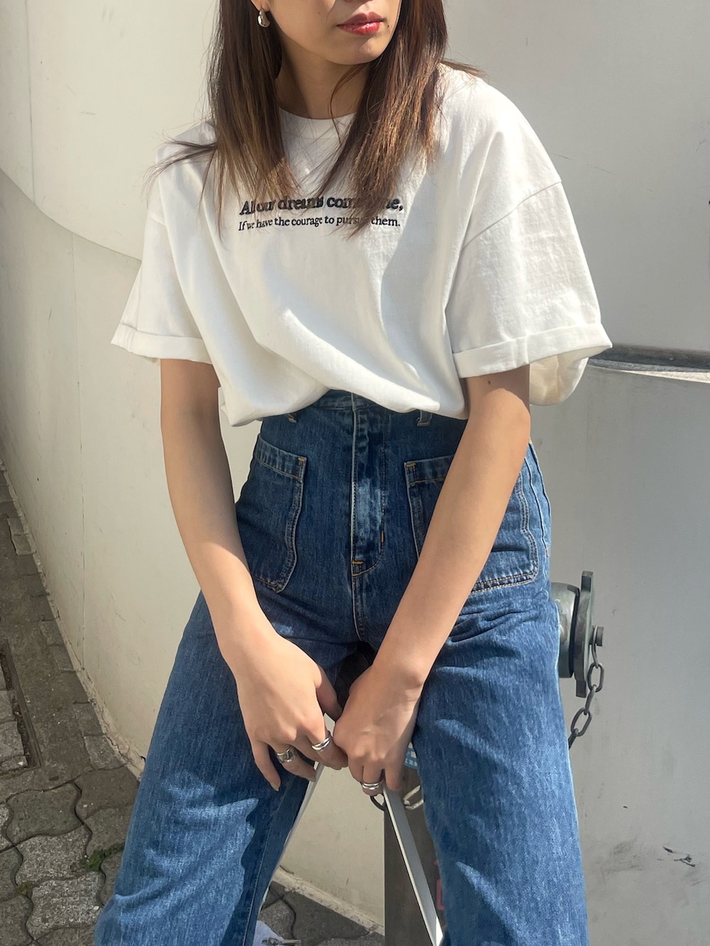 ホワイト系のTシャツ/カットソー、ブルー系のデニムパンツ、ホワイト系のハンドバッグを着用したレディースの春コーディネートの4枚目の写真