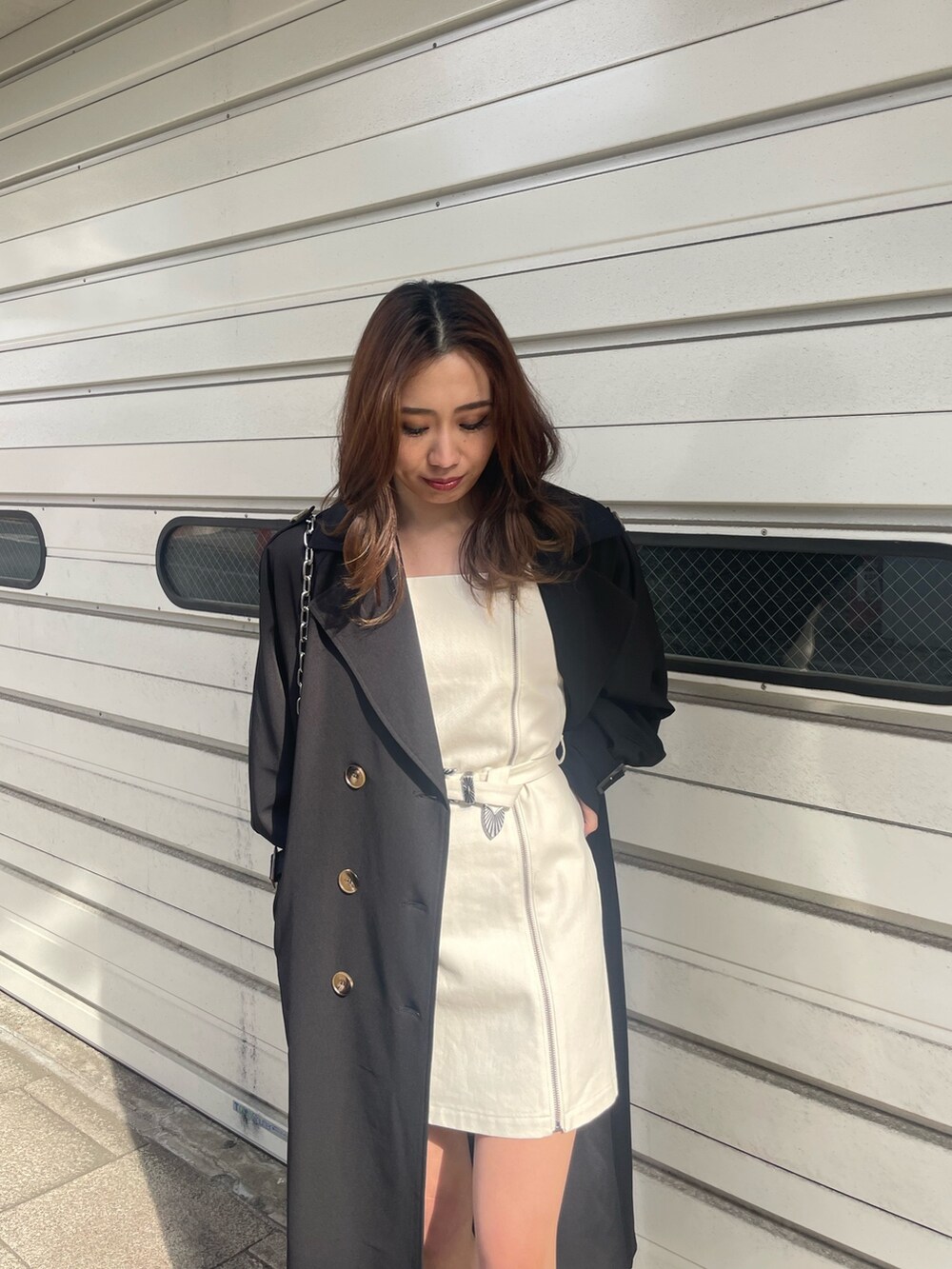 ブラック系のショルダーバッグ、ブラック系のトレンチコート、ホワイト系のワンピースを着用したレディースの冬コーディネートの4枚目の写真