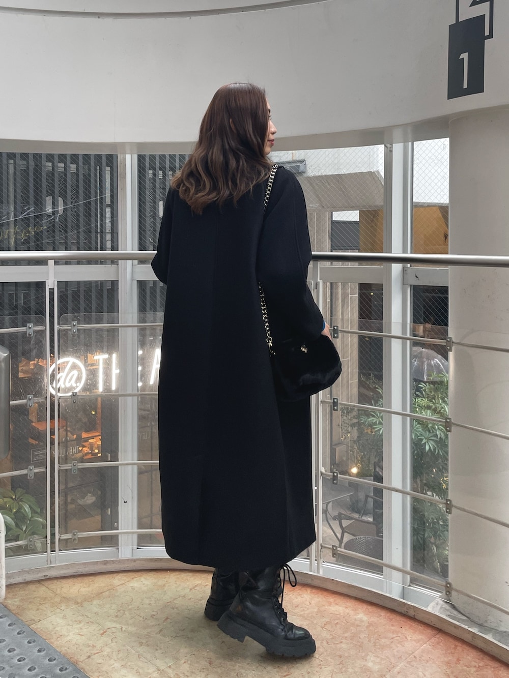 ブラック系のブーツ、ブラック系のその他パンツ、ブラック系のショルダーバッグを着用したレディースの冬コーディネートの2枚目の写真