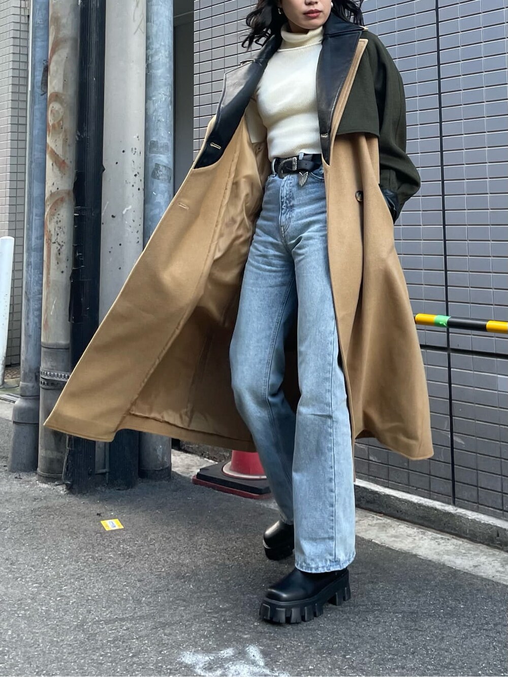ブルー系のデニムパンツ、ブラック系のブーツ、ホワイト系のニット/セーターを着用したレディースの冬コーディネートの3枚目の写真