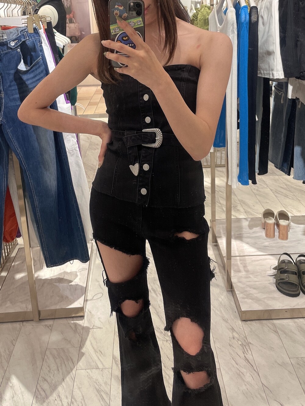 ブラック系のチューブトップ、ブラック系のデニムパンツ、ブラック系のサンダルを着用したレディースの春コーディネートの3枚目の写真