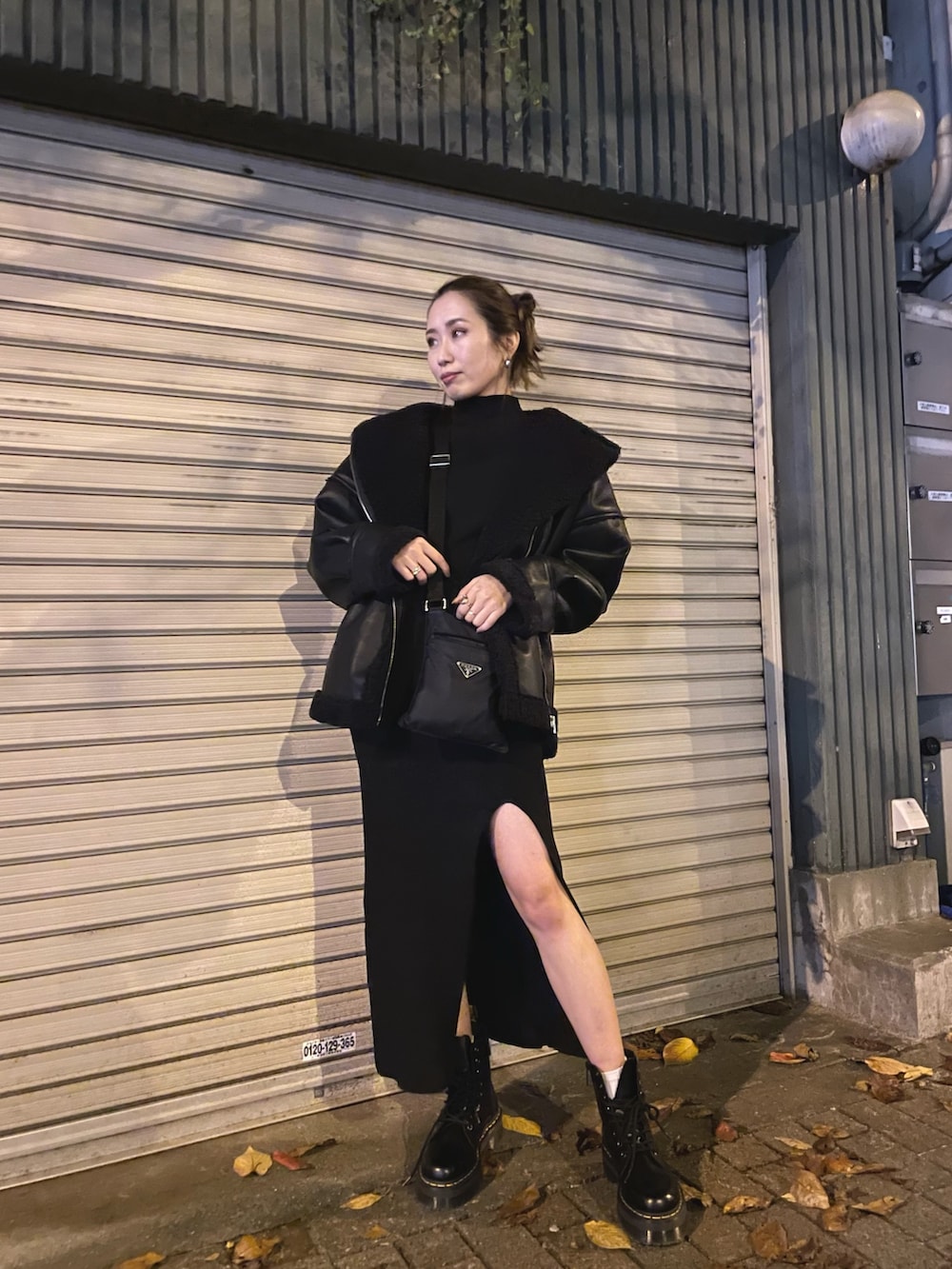 ブラック系のブルゾン、ブラック系のワンピース、ブラック系のブーツを着用したレディースの冬コーディネートの4枚目の写真