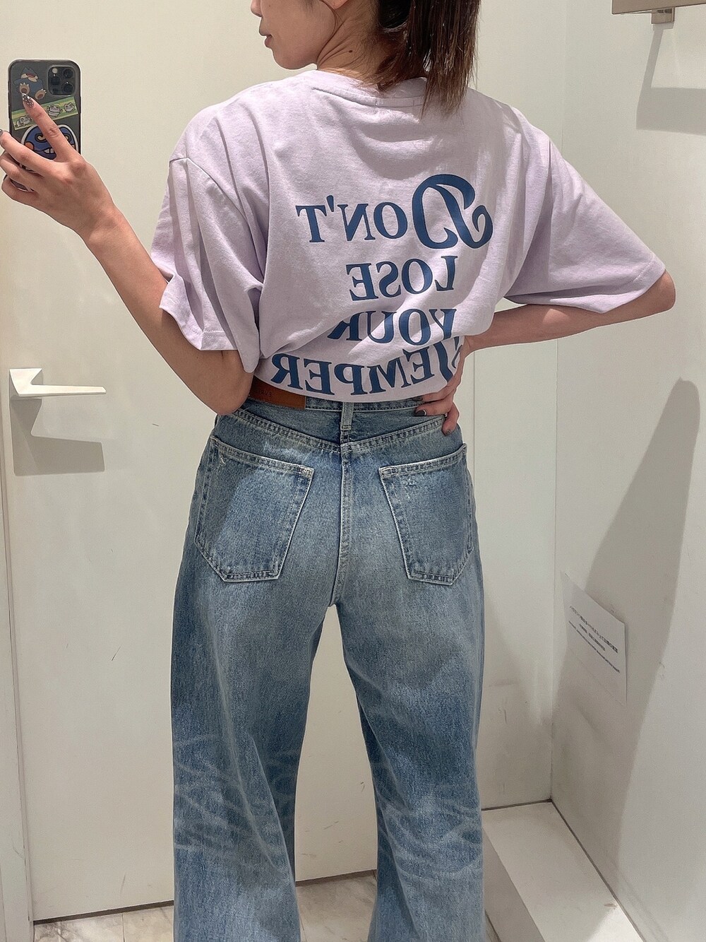 パープル系のTシャツ/カットソー、ブルー系のデニムパンツ、ホワイト系のスニーカーを着用したレディースの春コーディネートの2枚目の写真