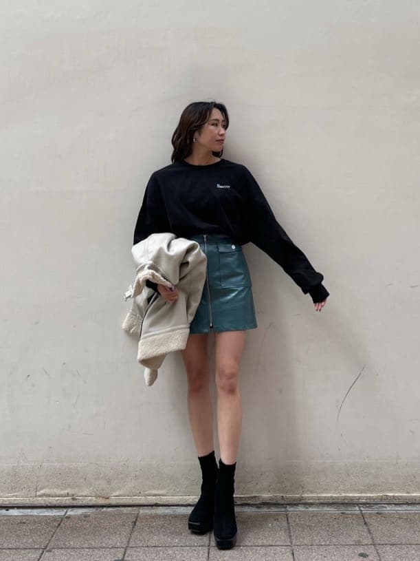 ホワイト系のブルゾン、ブルー系のスカート、ブラック系のTシャツ/カットソーを着用したレディースの冬コーディネートの3枚目の写真