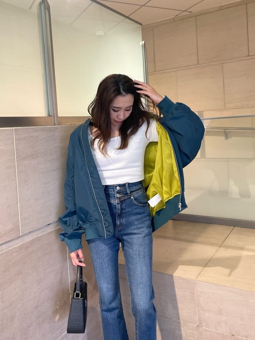 ブルー系のMA-1、ブラック系のブーツ、ブルー系のデニムパンツを着用したレディースの秋コーディネートの3枚目の写真